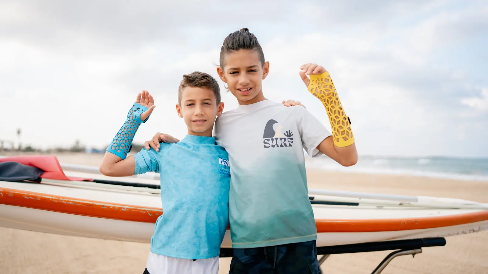 Two boys on the beach, both wearing Gero3D casts